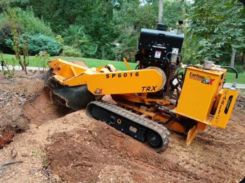 Tracked stump grinder grinding a large stump in a Greenville, SC front yard